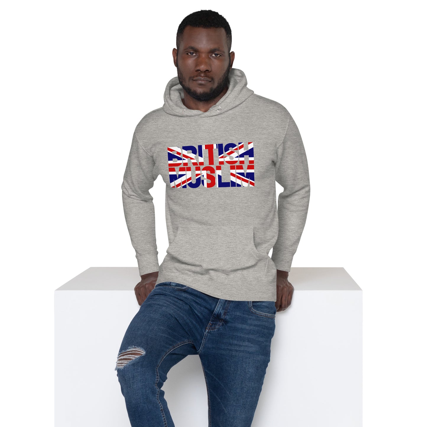 A man wearing a carbon grey coloured Unisex Hoodie with the text saying BRITISH MUSLIM that is also in the colours of the british flag.