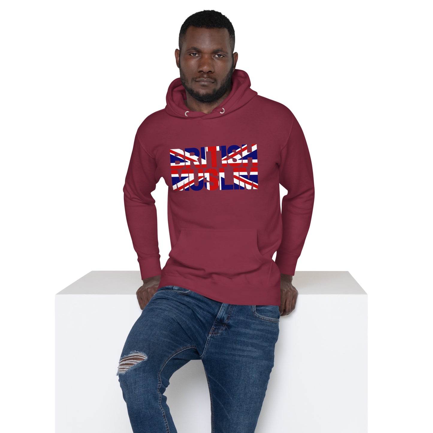 A man wearing a maroon coloured Unisex Hoodie with the text saying BRITISH MUSLIM that is also in the colours of the british flag.